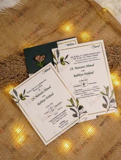 Complete botanical wedding card set with green envelope on burlap backdrop