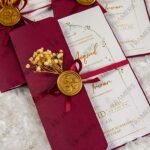 Burgundy gatefold wedding invitations with wax seals and dried baby's breath