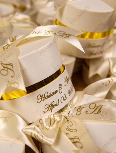 Close-up round cream Nikkah bid boxes with gold printed ribbon
