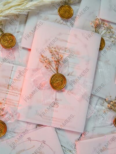 Close-up of white organza bow with gold wax seal and baby's breath